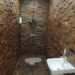 een badkamer met een wastafel en een bakstenen muur bij The Retreat in Lusaka