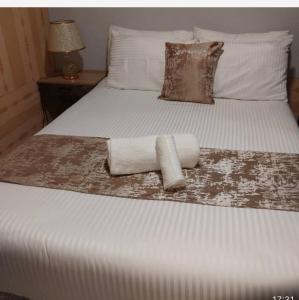 een bed met twee opgerolde handdoeken erop bij The Retreat in Lusaka