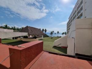 a view of a building and a grassy yard at La mejor ubicación Condomar 133 in Puerto Vallarta