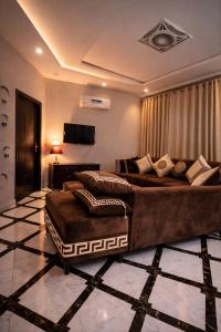 a large bedroom with two beds and a television at LMY Residency - Bahria Town Lahore in Lahore