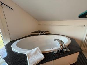 een badkuip in een badkamer met een wastafel bij LaVida Star Alpine Hideaway Thun, Sauna, free parking in Blumenstein +45 foto's