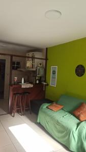 a bedroom with green walls and a bed and a table at Jardim Caribenho in Arraial do Cabo