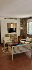 un soggiorno con un divano, sedie e un tavolo di Posada San Andres a La Cumbre