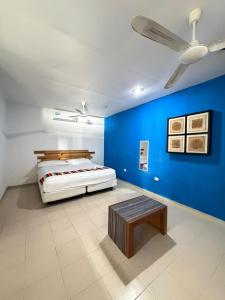 a bedroom with a bed with a blue wall at Hostal Casa Bohemia in Mérida +31 photos