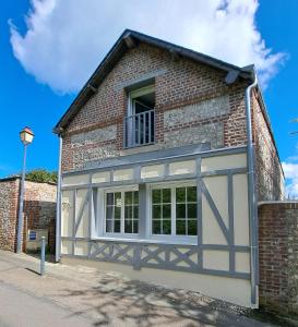 a building with a garage with a window at La Grive - Petit nid douillet proche de la plage in Étretat