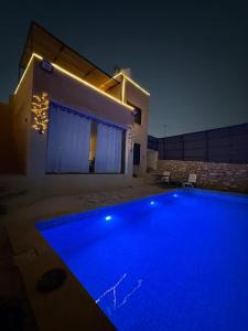 een zwembad voor een huis 's nachts bij Lion's Den Chaletاستراحة وشاليه في جرش in Jerash