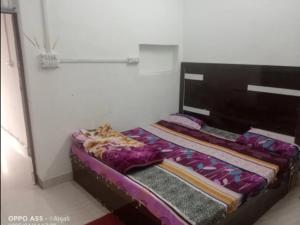 a cat laying on a bed in a room at Chaudhary dharamshala in Jāmb