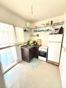 een kleine keuken met een spoelbak en een koelkast bij Face à la Mer TANGER in Hauara