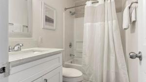 a white bathroom with a toilet and a sink at Landing Apartments - The Carlisle at Dunedin in Dunedin +31 photos