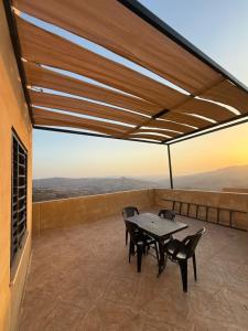 een tafel en stoelen op een balkon met uitzicht bij Lion's Den Chaletاستراحة وشاليه في جرش in Jerash +12 foto's