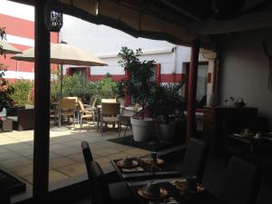 d'une terrasse avec des tables, des chaises et un parasol. dans l'établissement Hotel Cote Patio, à Nîmes