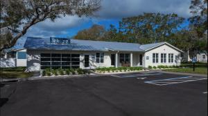a white building with a parking lot at Landing Apartments - The Carlisle at Dunedin in Dunedin