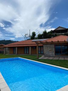 een blauw zwembad voor een huis bij Refúgio do Vale in Celorico de Basto