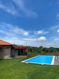 a swimming pool in a yard next to a house at Refúgio do Vale in Celorico de Basto