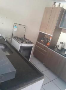 une cuisine avec une cuisinière et un comptoir dans l'établissement Casa espaçosa, à Garanhuns