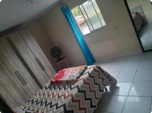 une chambre avec un lit, une fenêtre et un miroir dans l'établissement Casa espaçosa, à Garanhuns