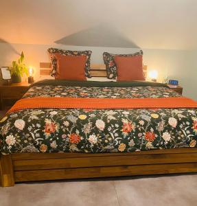 a bedroom with a large bed with a floral comforter at Nido Vela Appartement in Wesseling