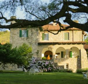una grande casa in pietra con sedie di fronte di Posada San Andres a La Cumbre