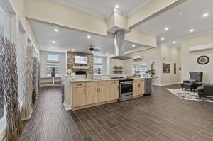 een grote keuken met houten kasten en een fornuis bovenste oven bij Landing Modern 2BD Gym Pool in Kelim