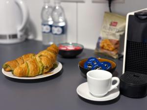 a table with a plate of croissants and a cup of coffee at D' Suites Holiday Apartments in Il-Gżira