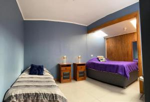 a bedroom with two beds and a purple bedspread at Casa Lepeley Colimilla in Frutillar