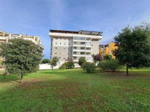 a large apartment building with trees in a park at Nenni House in Sassari