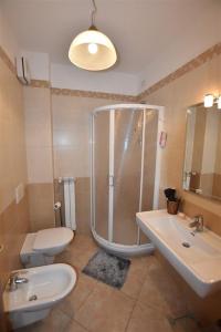 a bathroom with a shower and a toilet and a sink at Nenni House in Sassari