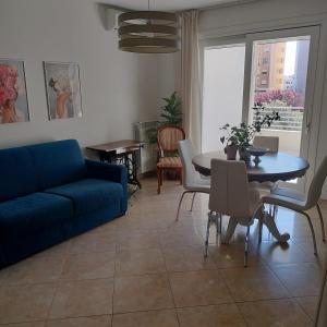 a living room with a blue couch and a table at Nenni House in Sassari