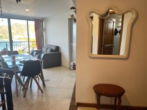 een woonkamer met een tafel en een spiegel bij Alojamiento Peñón del rodadero in Santa Marta