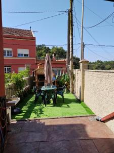 a patio with a table and chairs on the grass at Casa Seán in Boiro