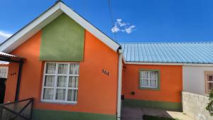 ein orange-grünes Haus mit Metalldach in der Unterkunft Valle del Río Chico in Gobernador Gregores