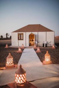 ein weißes Zelt mit Lichtern davor in der Unterkunft sand luxury camp in Merzouga