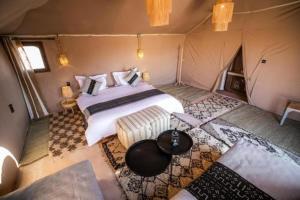 ein großes Schlafzimmer mit einem Bett und einer Couch in der Unterkunft sand luxury camp in Merzouga