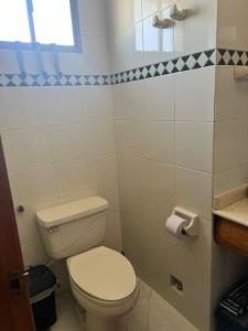 een kleine badkamer met een toilet en een raam bij Alojamiento Peñón del rodadero in Santa Marta