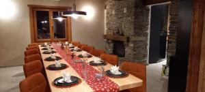 une longue table dans une pièce avec des chaises orange dans l'établissement Chalet prestige 14 pers au pied des pistes, à Ceillac