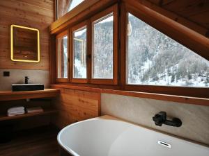 une salle de bain avec une baignoire et une fenêtre dans l'établissement Chalet prestige 14 pers au pied des pistes, à Ceillac