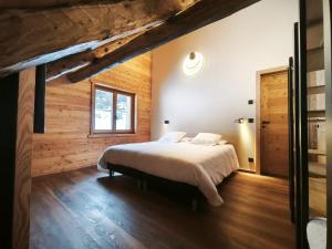 une chambre avec un lit et un mur en bois dans l'établissement Chalet prestige 14 pers au pied des pistes, à Ceillac