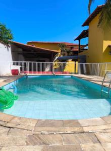 a swimming pool in front of a house at Casinha Guest House in Saquarema +13 photos