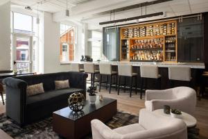 een woonkamer met een bank en een bar bij Fairfield Inn & Suites Madison Historic Eagle Cotton Mill in Madison