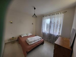 een kleine slaapkamer met een bed en een raam bij Loubarie 