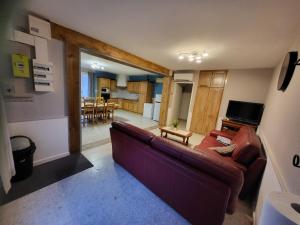a living room with a couch and a kitchen at Loubarie 