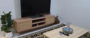 ein Wohnzimmer mit einem Fernseher auf einem hölzernen Entertainment-Center in der Unterkunft Mango Hill 3 Bedroom Family Accommodation in North Lakes + 4 Fotos