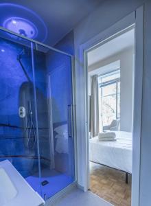 a blue bathroom with a shower and a bedroom at Giardini Rooms in Cremona