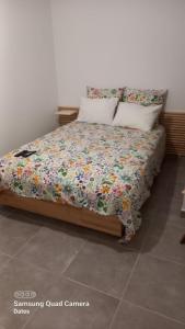 a bed with a floral comforter in a bedroom at Spacieux appartement dans résidence avec piscine in Bormes-les-Mimosas +24 photos