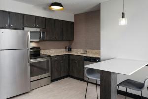 eine Küche mit Küchengeräten aus Edelstahl und Holzschränken in der Unterkunft Residence Inn by Marriott Fort Collins in Fort Collins