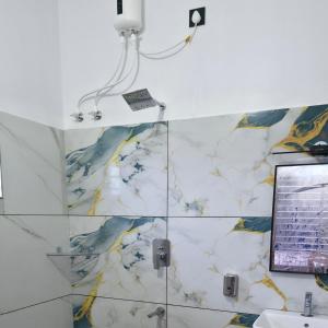 een badkamer met een wit-gele marmeren muur bij Metro Heights in Parunthumpara