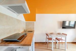 een keuken met een spoelbak en een tafel met stoelen bij Studio Wellness & Détente Cosy in Maubec +7 foto's