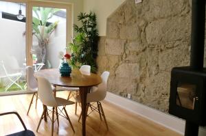 comedor con mesa, sillas y pared de piedra en Blue Garden - oporto charming townhouse, en Oporto
