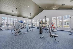 a gym with treadmills and machines in a building at Landing Apartments - Atlas Bluewood in Celina
