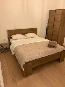 ein Schlafzimmer mit einem großen Bett mit hölzernem Kopfteil in der Unterkunft Holiday home Lemoni in Tivat